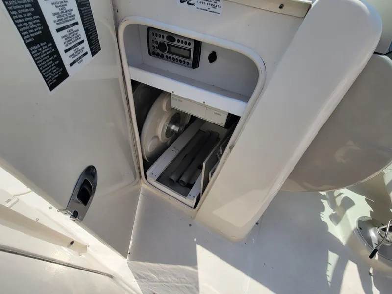 Slide: The Image of 2006 Sea Ray 220 Sundeck storage compartment with stereo system and equipment. - 32