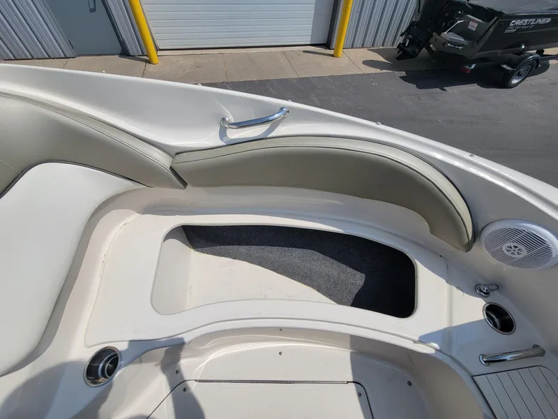 Slide: The Image of 2006 Sea Ray 220 Sundeck interior with seating and speaker, docked near a garage. - 33
