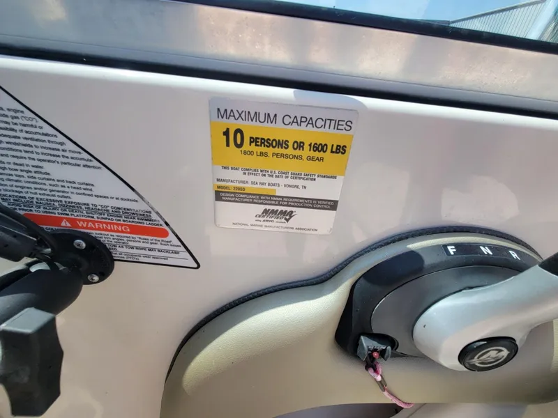 Slide: The Image of 2006 Sea Ray 220 Sundeck capacity label, 10 persons or 1600 lbs, steering control visible. - 35