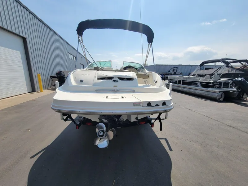 Slide: The Image of 2006 Sea Ray 220 Sundeck boat with canopy, parked outdoors on a sunny day. - 4