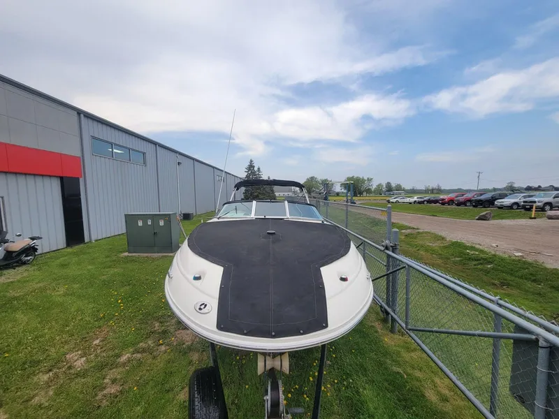 Slide: The Image of 2006 Sea Ray 220 Sundeck boat on trailer near industrial building. - 9