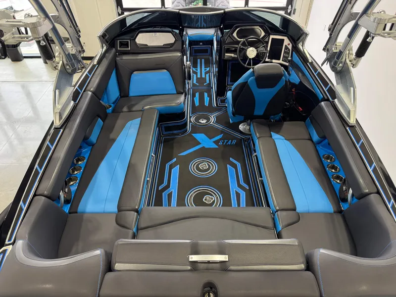 Slide: The Image of 2018 MasterCraft XStar interior with blue and black seating, modern dashboard, and stylish design. - 13