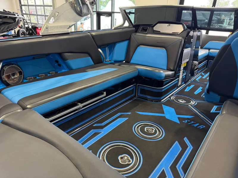 Slide: The Image of 2018 MasterCraft XStar interior with blue and black seating, modern design, and stylish flooring. - 14