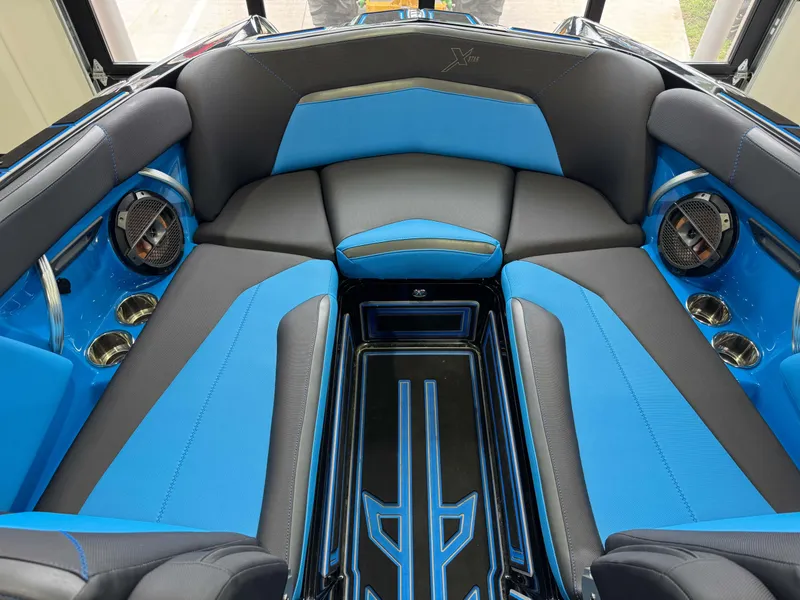 Slide: The Image of 2018 MasterCraft XStar interior with blue and black seating, cup holders, and speakers. - 20