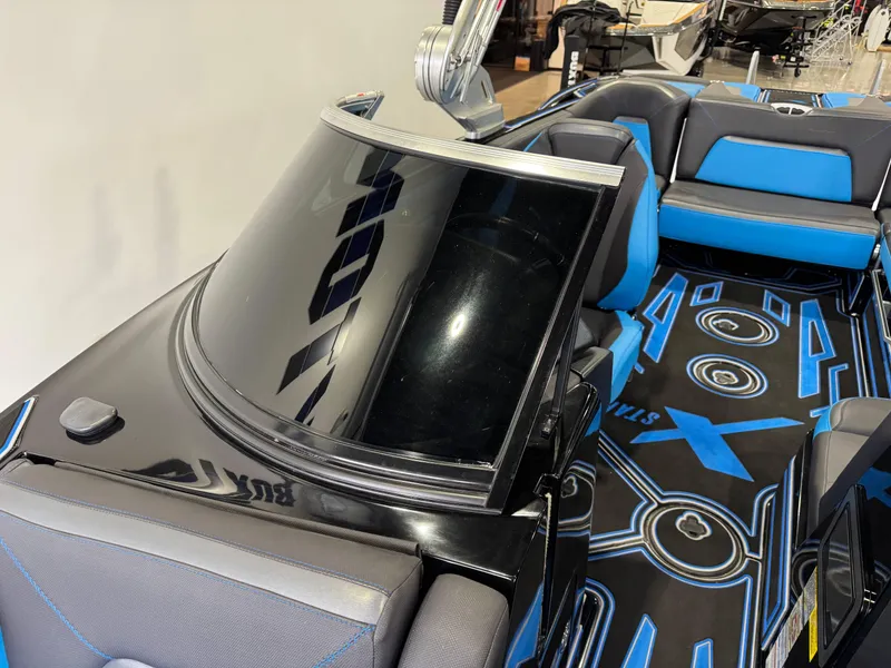 Slide: The Image of 2018 MasterCraft XStar boat interior with blue and black seating and custom flooring. - 23