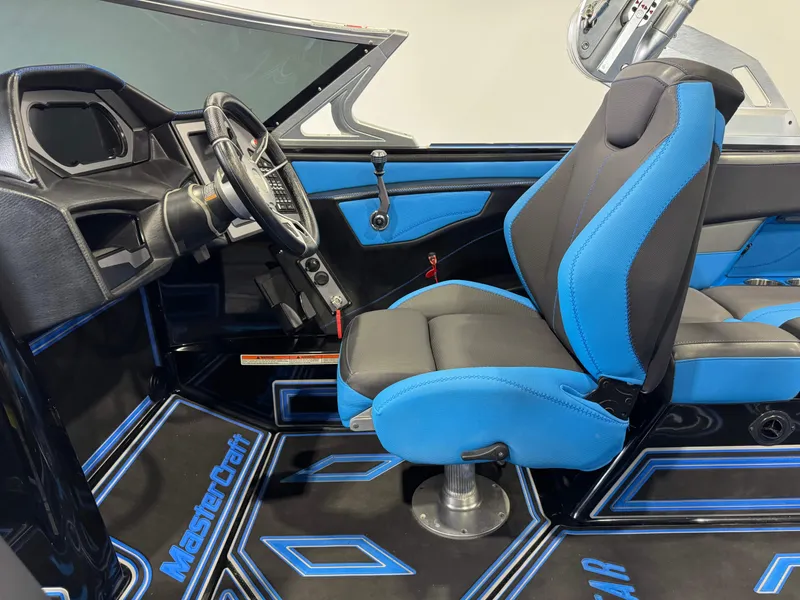 Slide: The Image of 2018 MasterCraft XStar interior with blue and black seating, modern dashboard, and steering wheel. - 26
