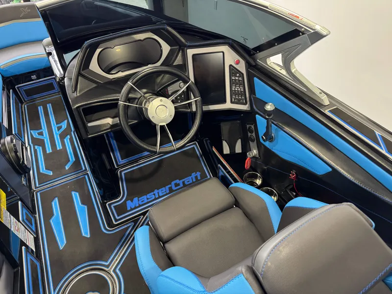 Slide: The Image of 2018 MasterCraft XStar boat interior with blue accents and modern dashboard controls. - 28