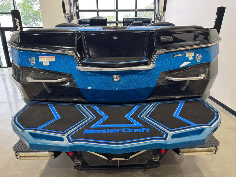 Slide: The Image of 2018 MasterCraft XStar boat rear view, featuring blue and black design with logo. - 8
