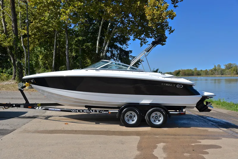 Slide: The Image of 2007 Cobalt 200 boat on trailer by a lake, surrounded by trees. - 11