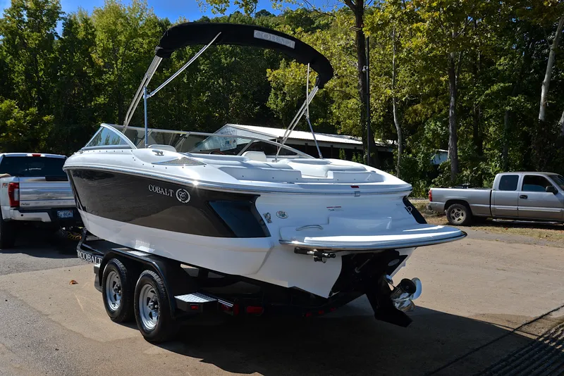 Slide: The Image of 2007 Cobalt 200 boat on trailer, parked outdoors with trees in the background. - 12