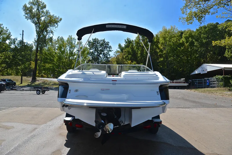 Slide: The Image of Rear view of a 2007 Cobalt 200 boat parked outdoors, surrounded by trees. - 13