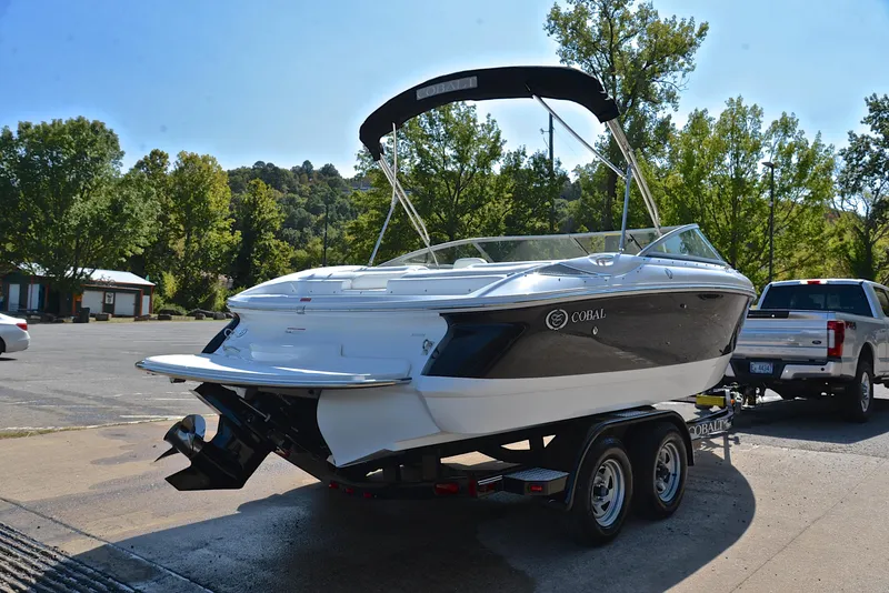 Slide: The Image of 2007 Cobalt 200 boat on trailer, parked outdoors near trees and vehicles. - 14