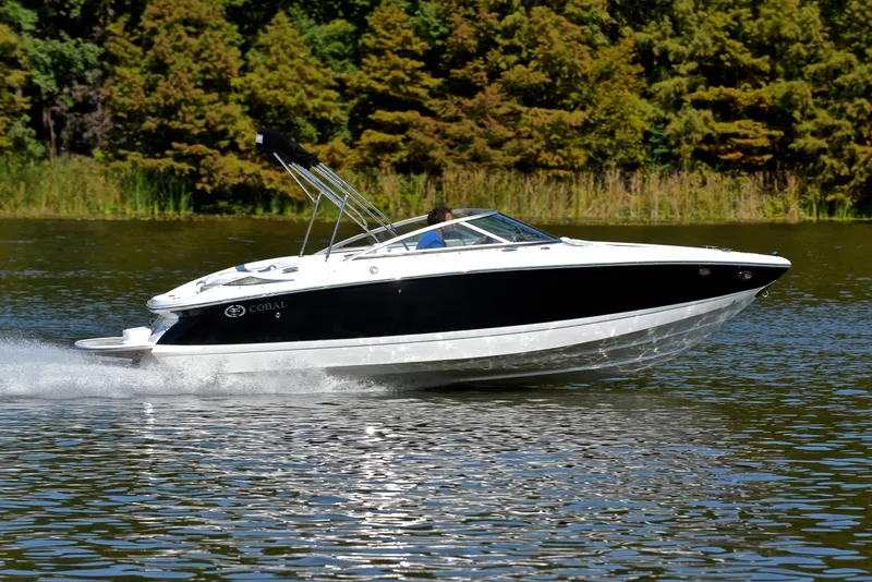Slide: The Image of 2007 Cobalt 200 boat cruising on a lake with lush green trees in the background. - 3