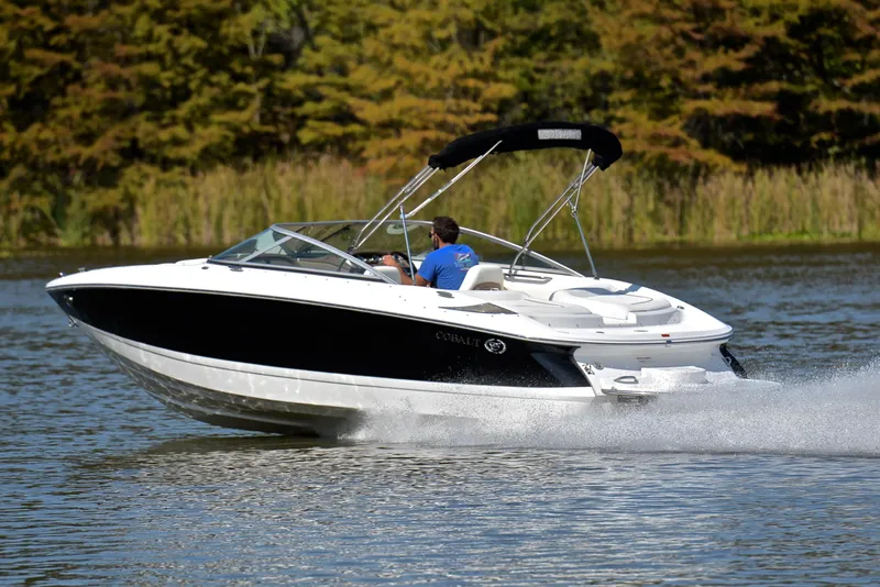 Slide: The Image of 2007 Cobalt 200 boat cruising on a lake with trees in the background. - 4