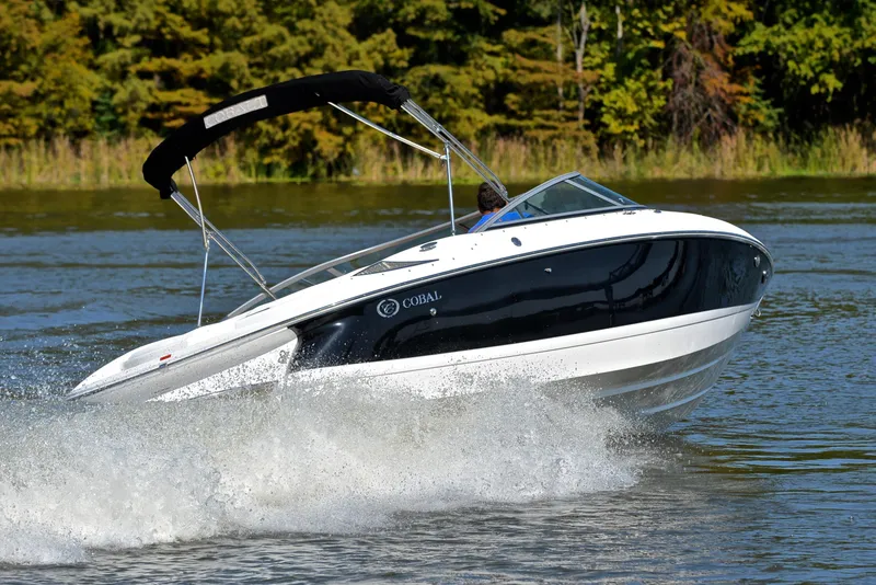 Slide: The Image of 2007 Cobalt 200 boat cruising on a lake with trees in the background. - 5