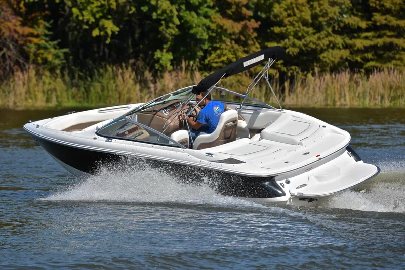 Slide: The Image of 2007 Cobalt 200 boat cruising on a lake with lush green trees in the background. - 6