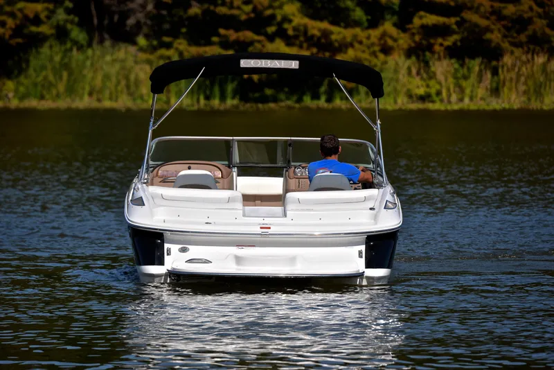 Slide: The Image of 2007 Cobalt 200 boat on a calm lake, rear view with lush greenery. - 8