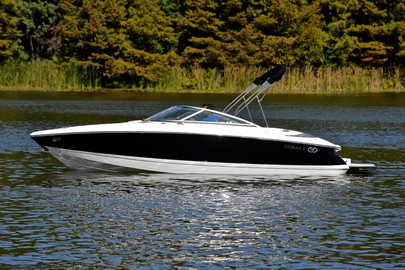 Slide: The Image of 2007 Cobalt 200 boat on a serene lake with lush green trees. - 9