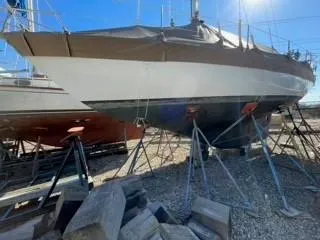 Slide: The Image of 1981 Cape Dory 33 Sloop sailboat on stands, under bright sunlight. - 10