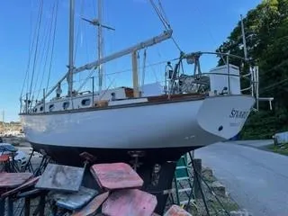 Slide: The Image of 1981 Cape Dory 33 Sloop sailboat on dry dock, surrounded by equipment. - 12
