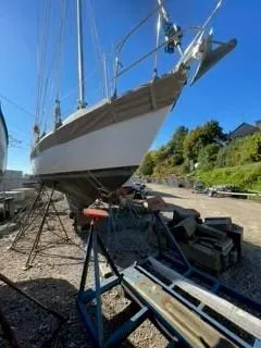 Slide: The Image of 1981 Cape Dory 33 Sloop sailboat on dry dock, clear sky background. - 13