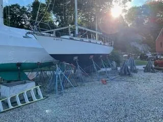 Slide: The Image of 1981 Cape Dory 33 Sloop sailboat on stands, sunlit background, gravel ground. - 14