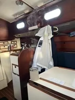 Slide: The Image of Interior of 1981 Cape Dory 33 Sloop with wooden cabinetry and nautical decor. - 21