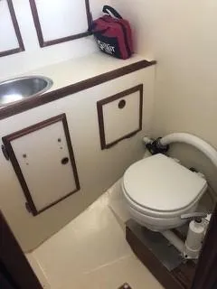 Slide: The Image of 1981 Cape Dory 33 Sloop bathroom with sink, storage, and marine toilet. - 23