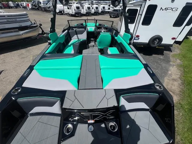 Slide: The Image of 2024 ATX Surf Boats 22 Type-S with teal and gray interior, parked near RVs. - 5