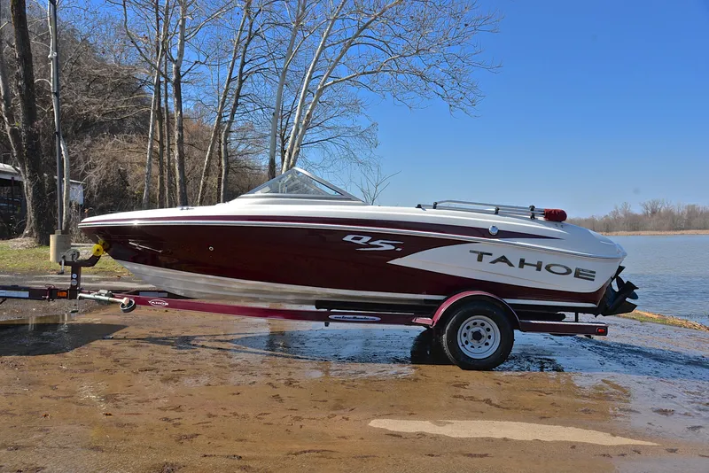 Slide: The Image of 2014 Tahoe Q5 boat on trailer by a lakeside, clear blue sky. - 11