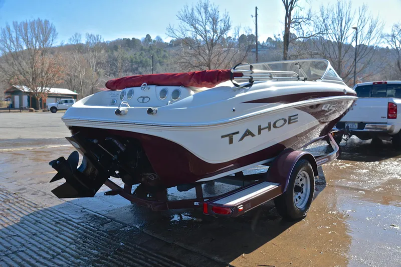 Slide: The Image of 2014 Tahoe Q5 boat on trailer, parked outdoors on a sunny day. - 14