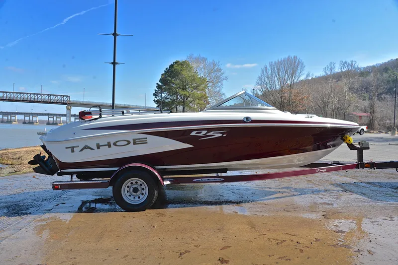 Slide: The Image of 2014 Tahoe Q5 boat on trailer by river, clear sky, and bridge in background. - 15