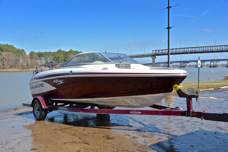 Slide: The Image of 2014 Tahoe Q5 boat on trailer by a river, with bridge in background. - 16