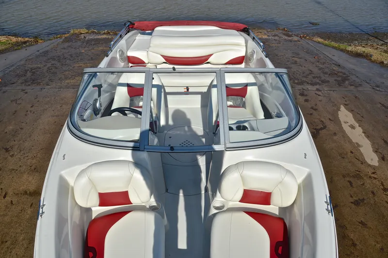 Slide: The Image of 2014 Tahoe Q5 boat with white and red interior, docked by the water. - 20