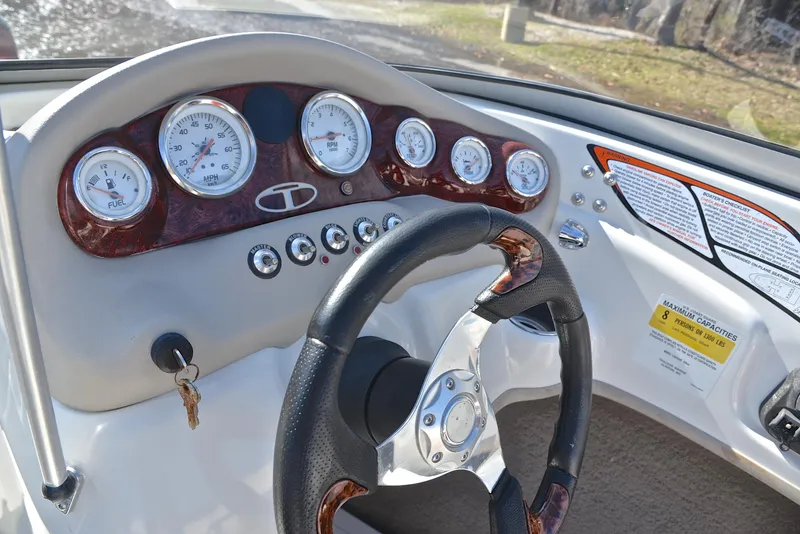 Slide: The Image of Steering wheel and dashboard of 2014 Tahoe Q5 boat with gauges and controls. - 26