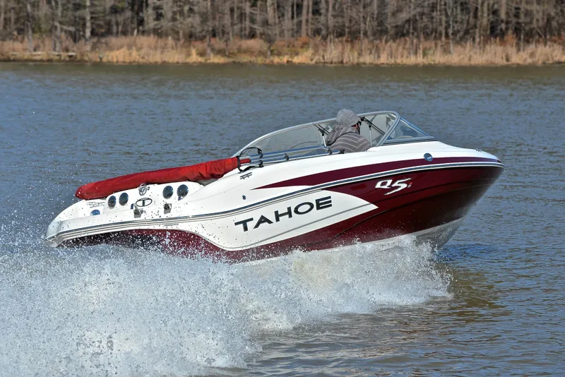 Slide: The Image of 2014 Tahoe Q5 boat cruising on a lake with a forested background. - 5