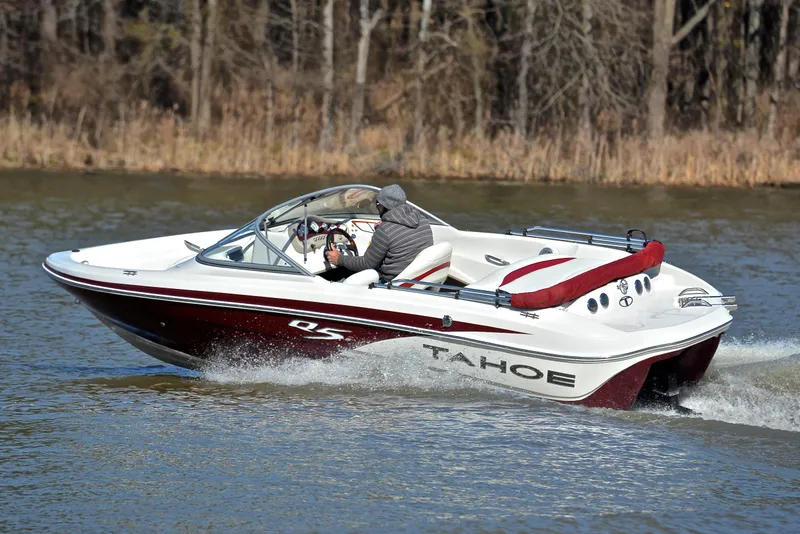Slide: The Image of 2014 Tahoe Q5 boat cruising on a lake with trees in the background. - 6