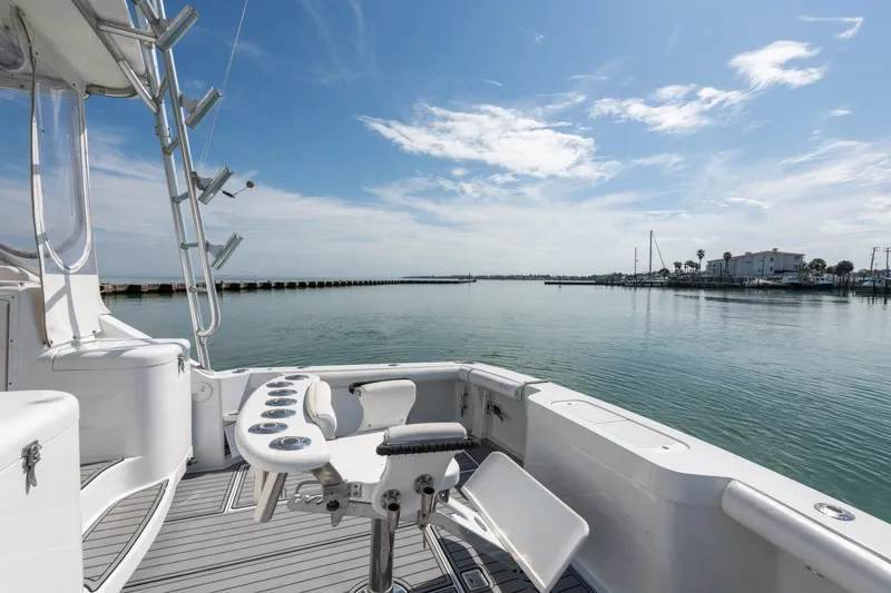 Slide: The Image of 2004 Cabo 40 Express yacht deck with fishing setup, overlooking calm waters and clear sky. - 14