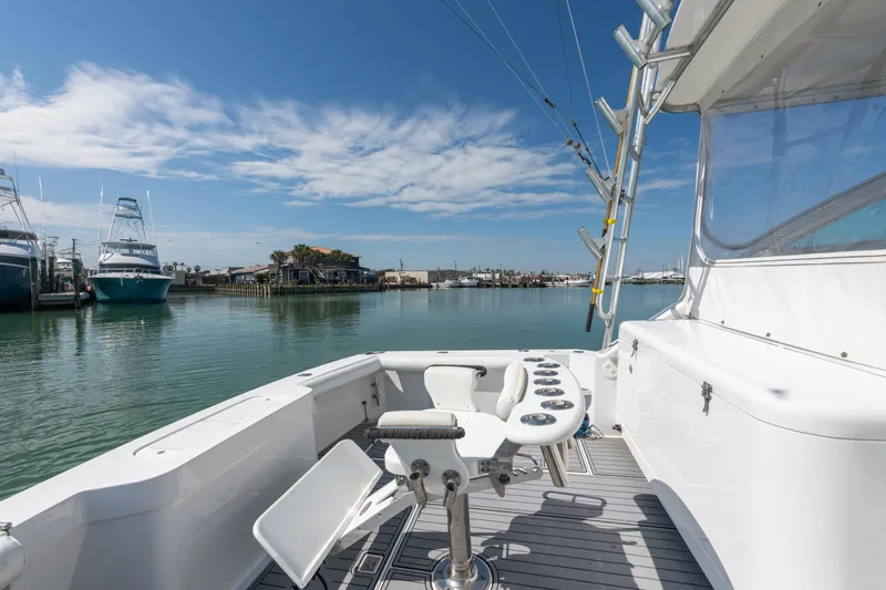 Slide: The Image of 2004 Cabo 40 Express yacht with fishing setup, docked in a serene marina. - 15
