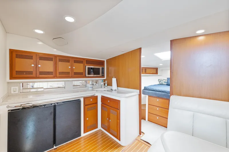 Slide: The Image of 2004 Cabo 40 Express yacht interior with modern kitchen and cozy sleeping area. - 16
