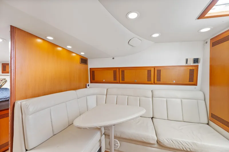 Slide: The Image of Luxurious interior of 2004 Cabo 40 Express yacht with white leather seating and wooden accents. - 18