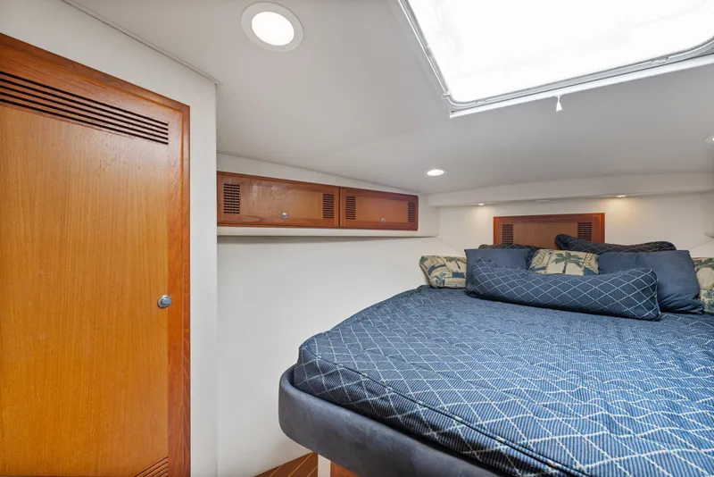 Slide: The Image of Interior cabin of 2004 Cabo 40 Express yacht with bed and wooden storage. - 21