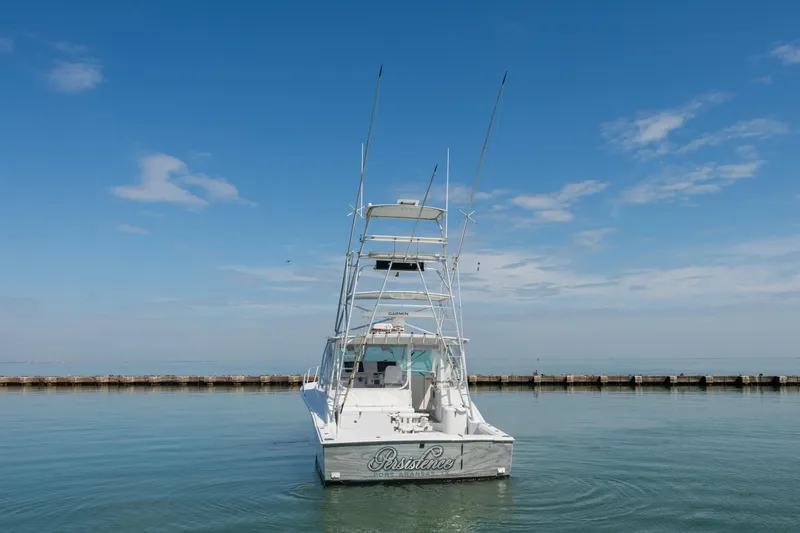 Slide: The Image of 2004 Cabo 40 Express boat on calm water under a clear blue sky. - 4