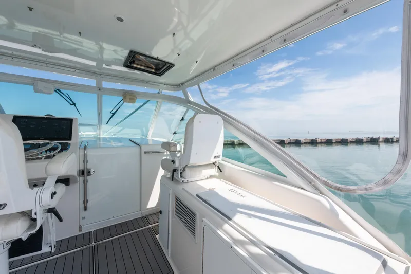 Slide: The Image of 2004 Cabo 40 Express yacht interior with helm, overlooking calm sea and clear sky. - 6