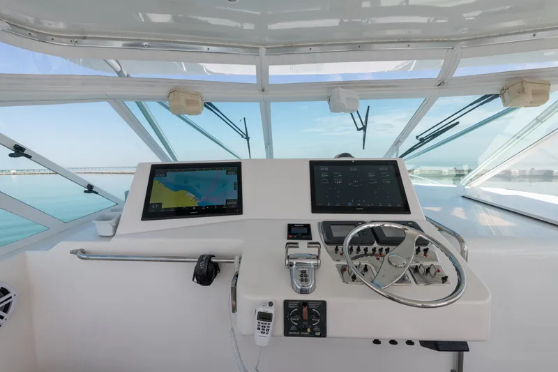 Slide: The Image of Helm of 2004 Cabo 40 Express boat with navigation screens and steering wheel. - 7