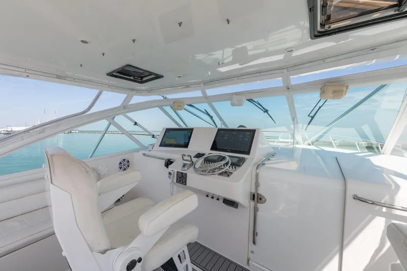 Slide: The Image of Helm of 2004 Cabo 40 Express yacht with modern navigation equipment and white seating. - 9