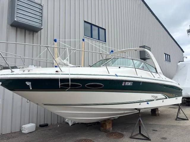 The Image of 2000 Sea Ray 280 SS boat on stands, parked near a metal building. - 1