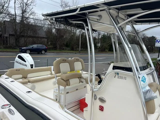 Slide: The Image of 2020 Key West 239 FS boat with Honda outboard motor, parked near a road. - 14