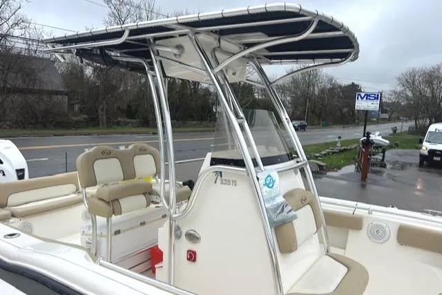 Slide: The Image of 2020 Key West 239 FS boat with T-top and seating, parked near a road. - 18