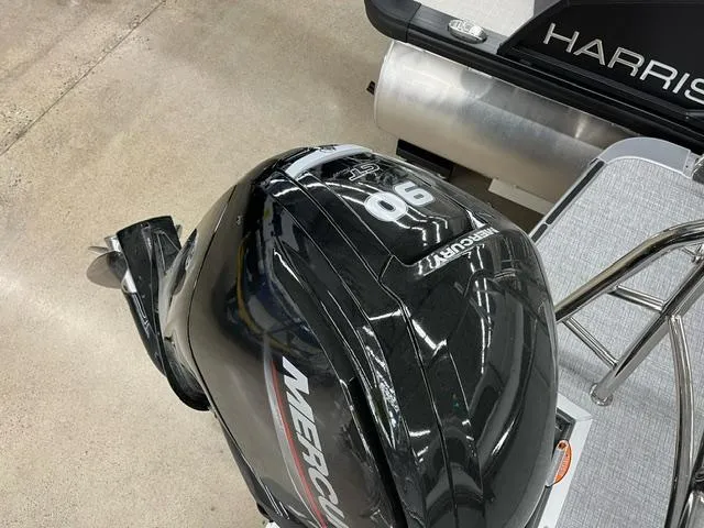 Slide: The Image of 2024 Harris Cruiser 210 with Mercury 90 outboard motor, displayed indoors. - 16